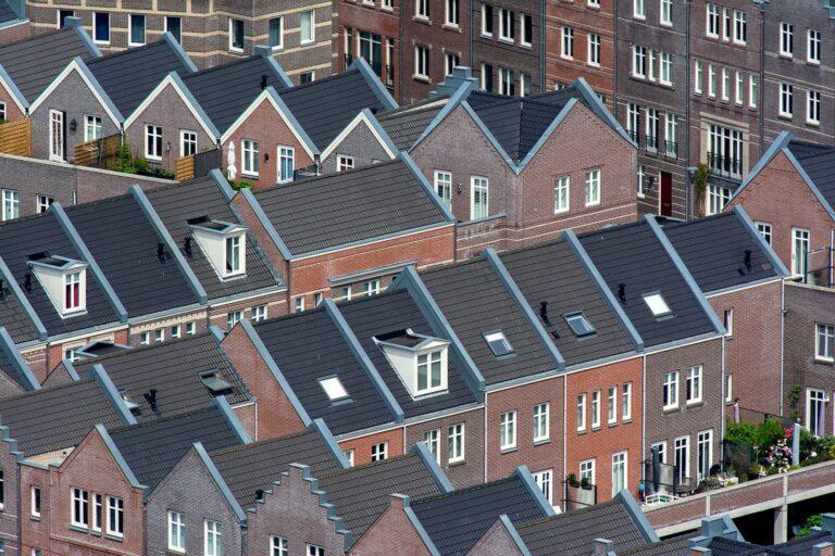 Voorkom dure schade: zo houd je jouw dak jarenlang in topconditie Aerial view of traditional Dutch townhouses in Den Haag, showcasing unique architecture.