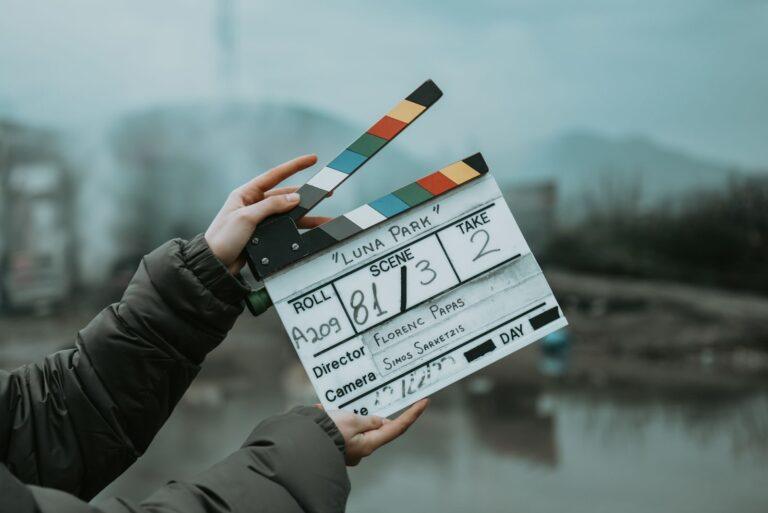 Close-up of a film clapperboard on an outdoor set, signaling scene start.